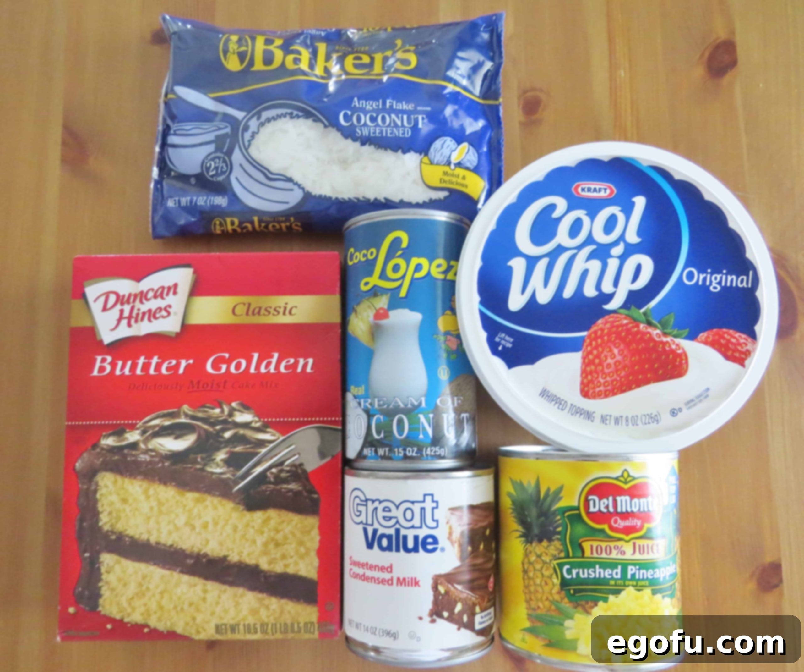 Piña Colada Paradise Poke Cake 5 A flat lay photo showing all the main ingredients for Pina Colada Poke Cake: butter cake mix, crushed pineapple, cream of coconut, sweetened condensed milk, sweetened flaked coconut, and cool whip.