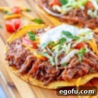Crock Pot Mexican Shredded Beef shown served on a tostada