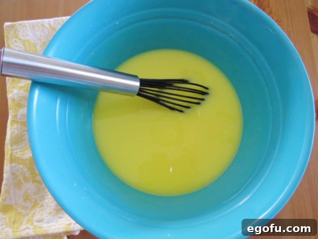 Whisking lemon pudding mix together in a bowl until thickened