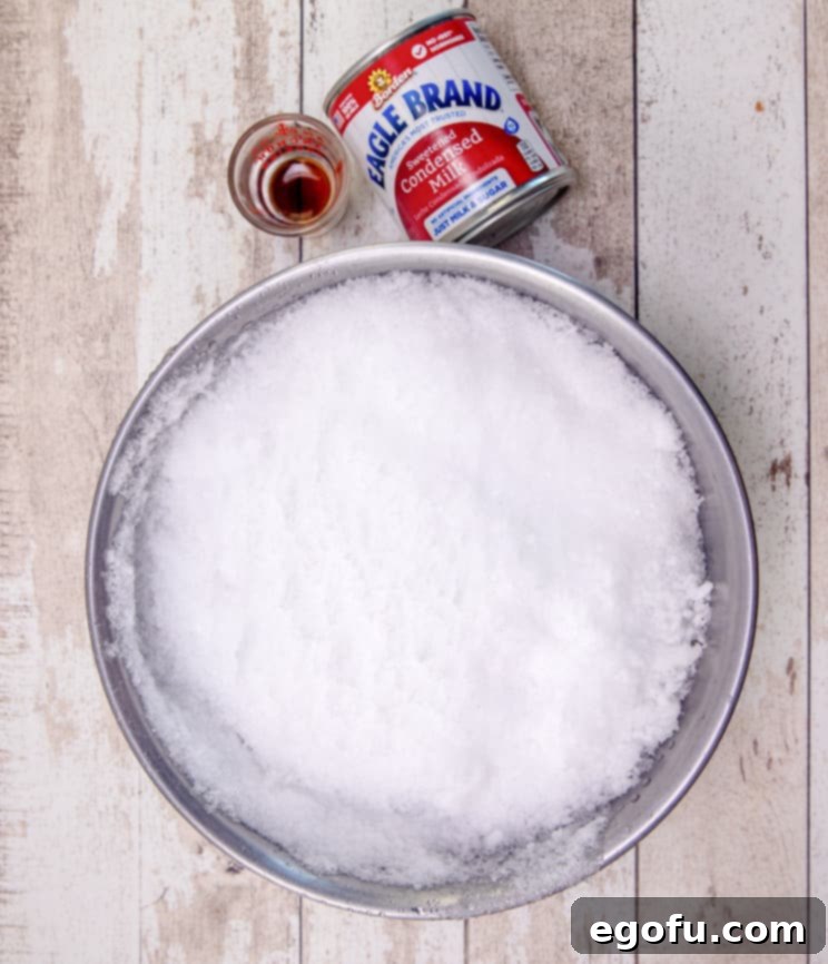 snow cream ingredients: fresh now, sweetened condensed milk and vanilla extract, laid out on a clean surface.