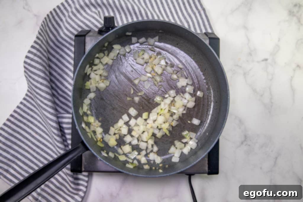 onion and garlic cooking in a saute pan.