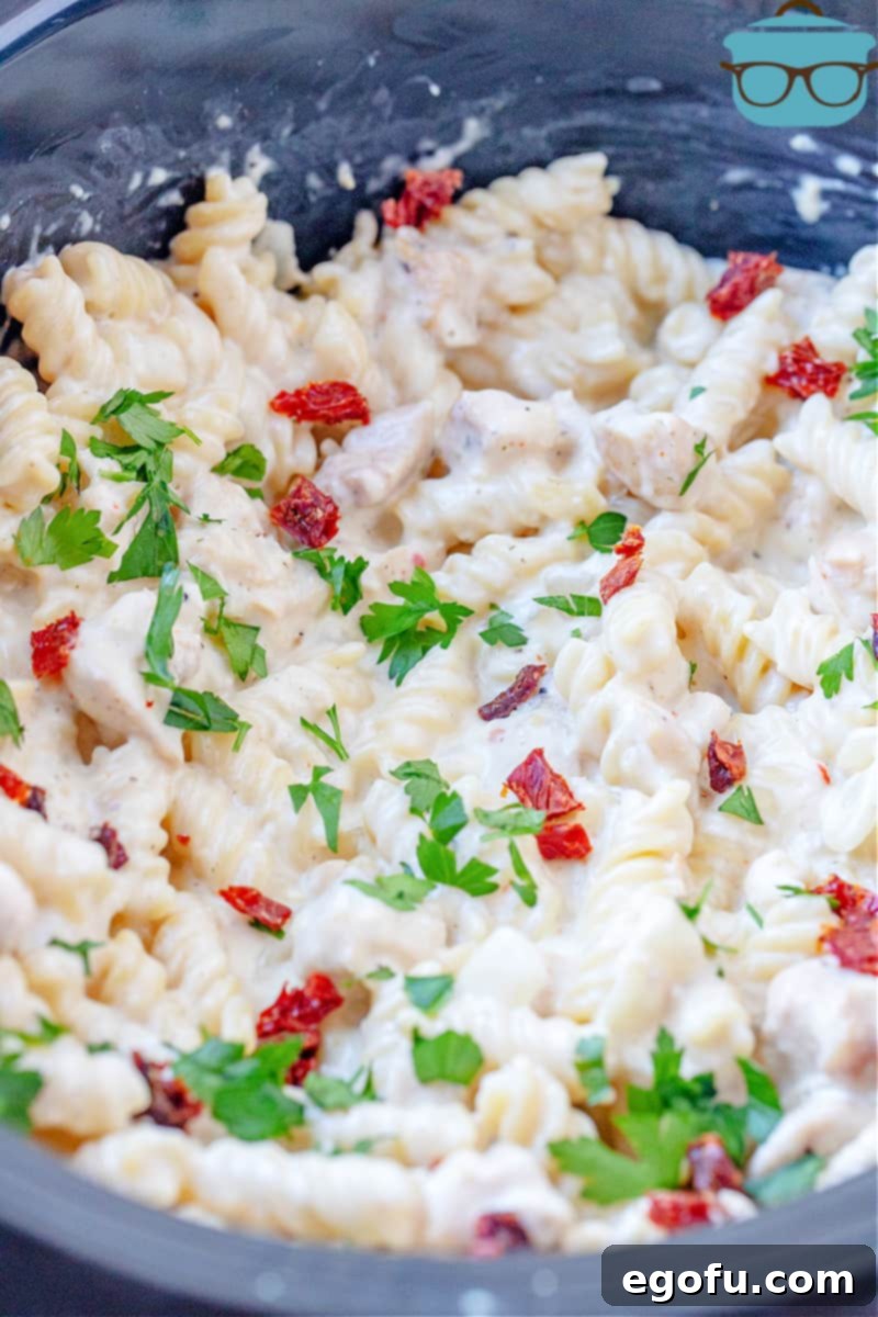 closeup of fully cooked creamy Italian chicken pasta inside slow cooker.
