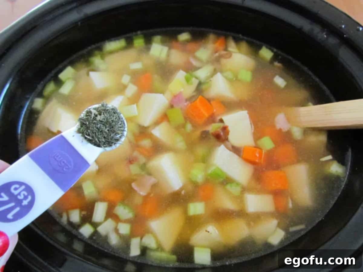 adding dill weed and garlic powder into crock pot with leeks and potatoes.
