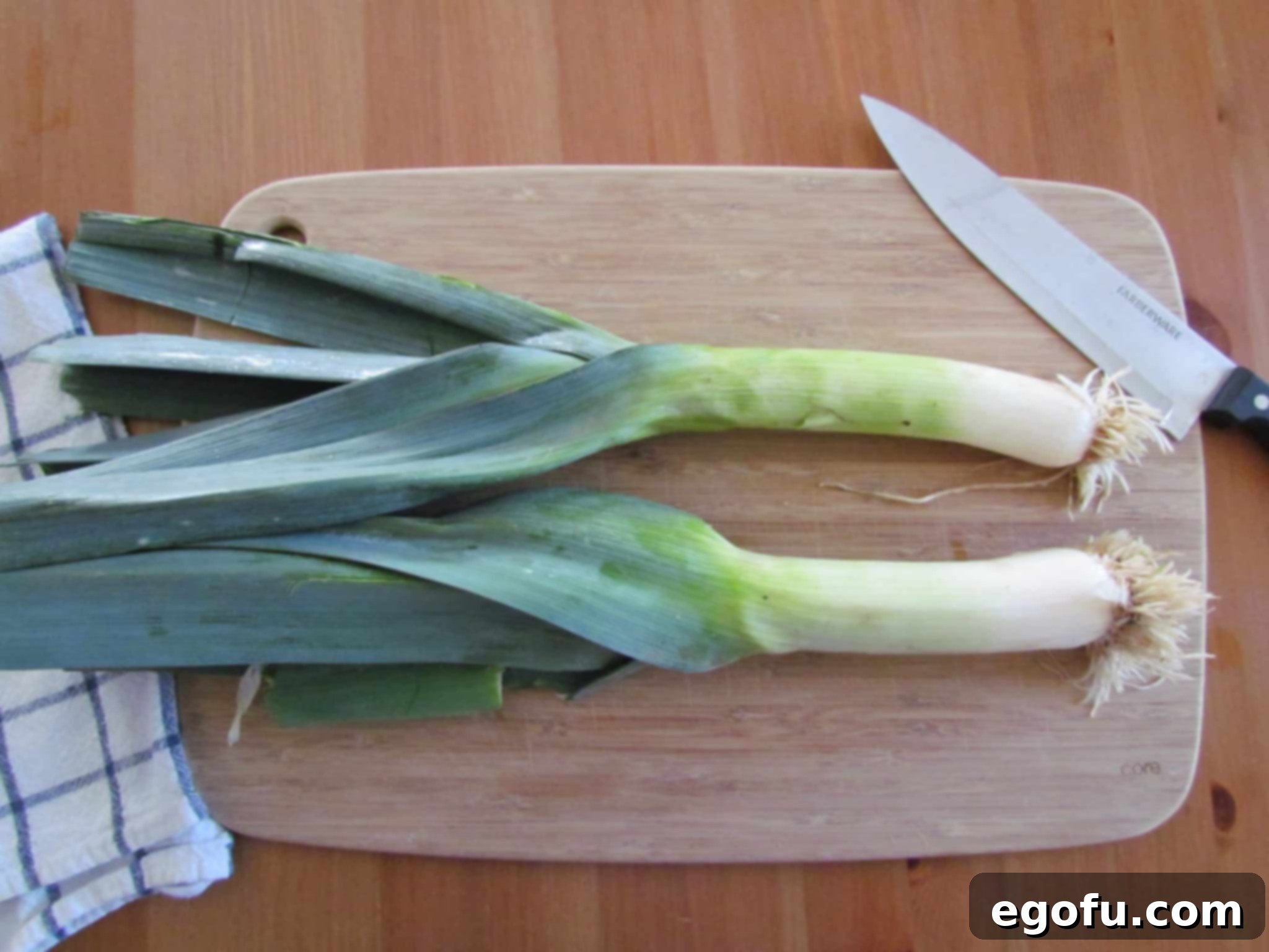 fresh leeks on a wooden cutting board.