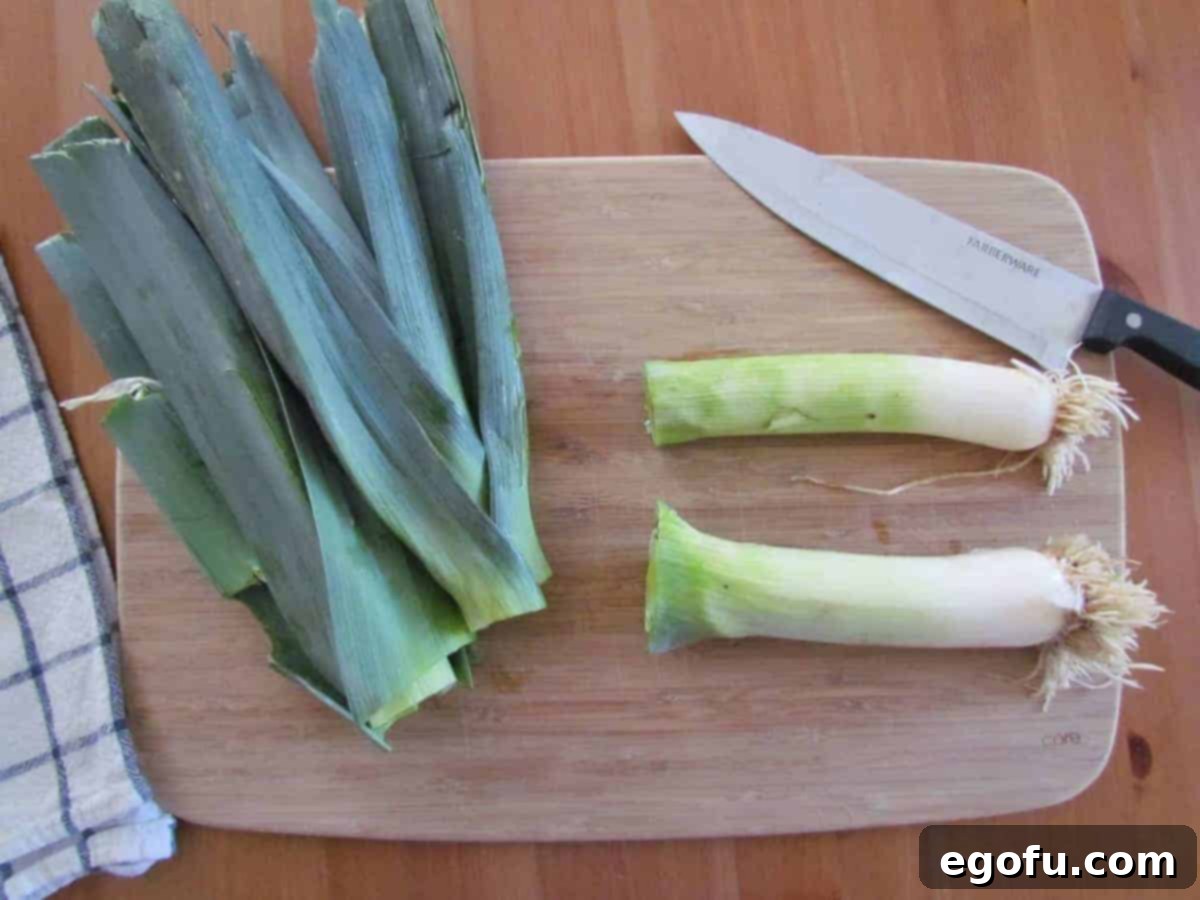 how to cut leeks, leeks shown cut in half on a cutting board.