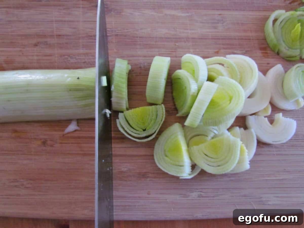 cutting and slicing leeks on a cutting board.