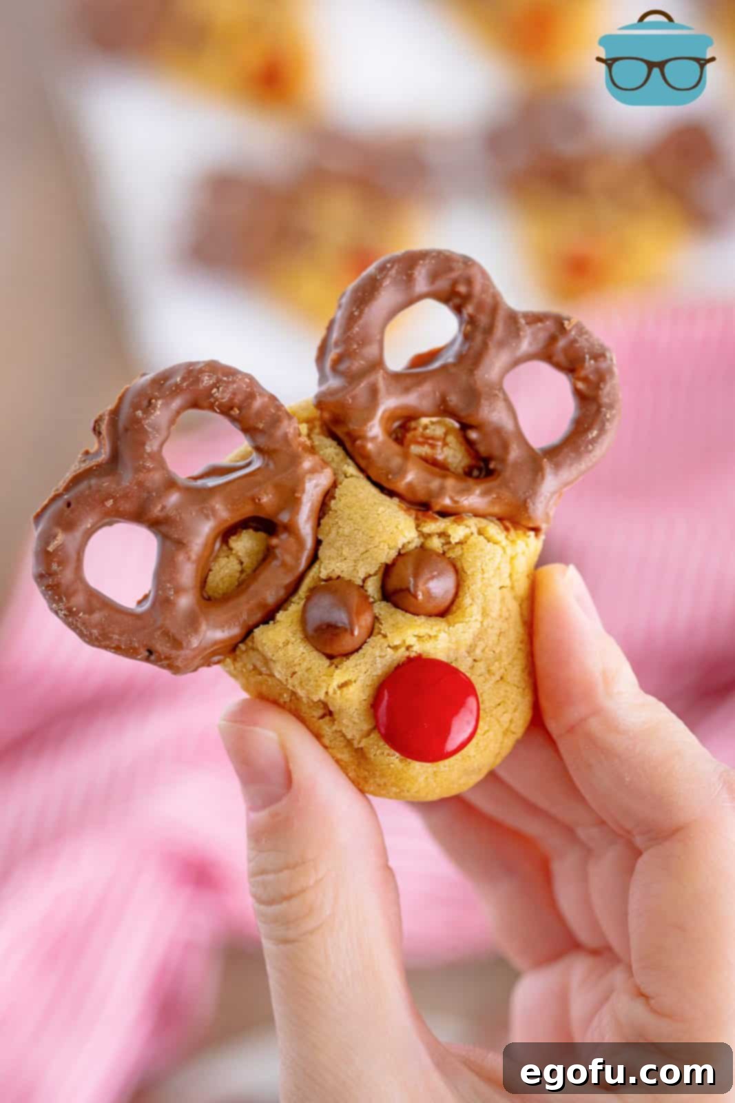 Red Nosed Reindeer Treats 2 a hand holding up a peanut butter Reindeer cookie.