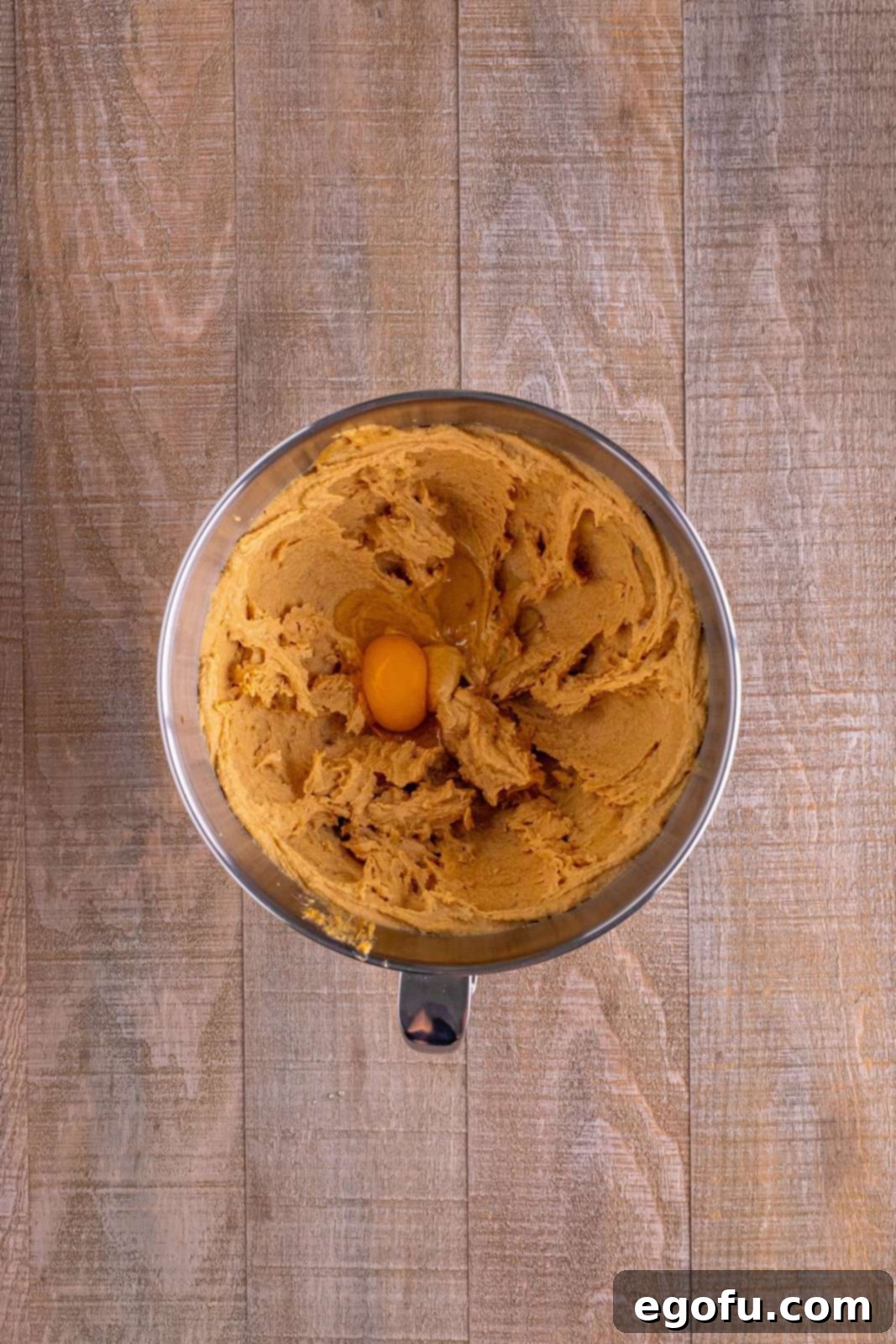 Red Nosed Reindeer Treats 6 egg added to peanut butter mixture in mixing bowl.