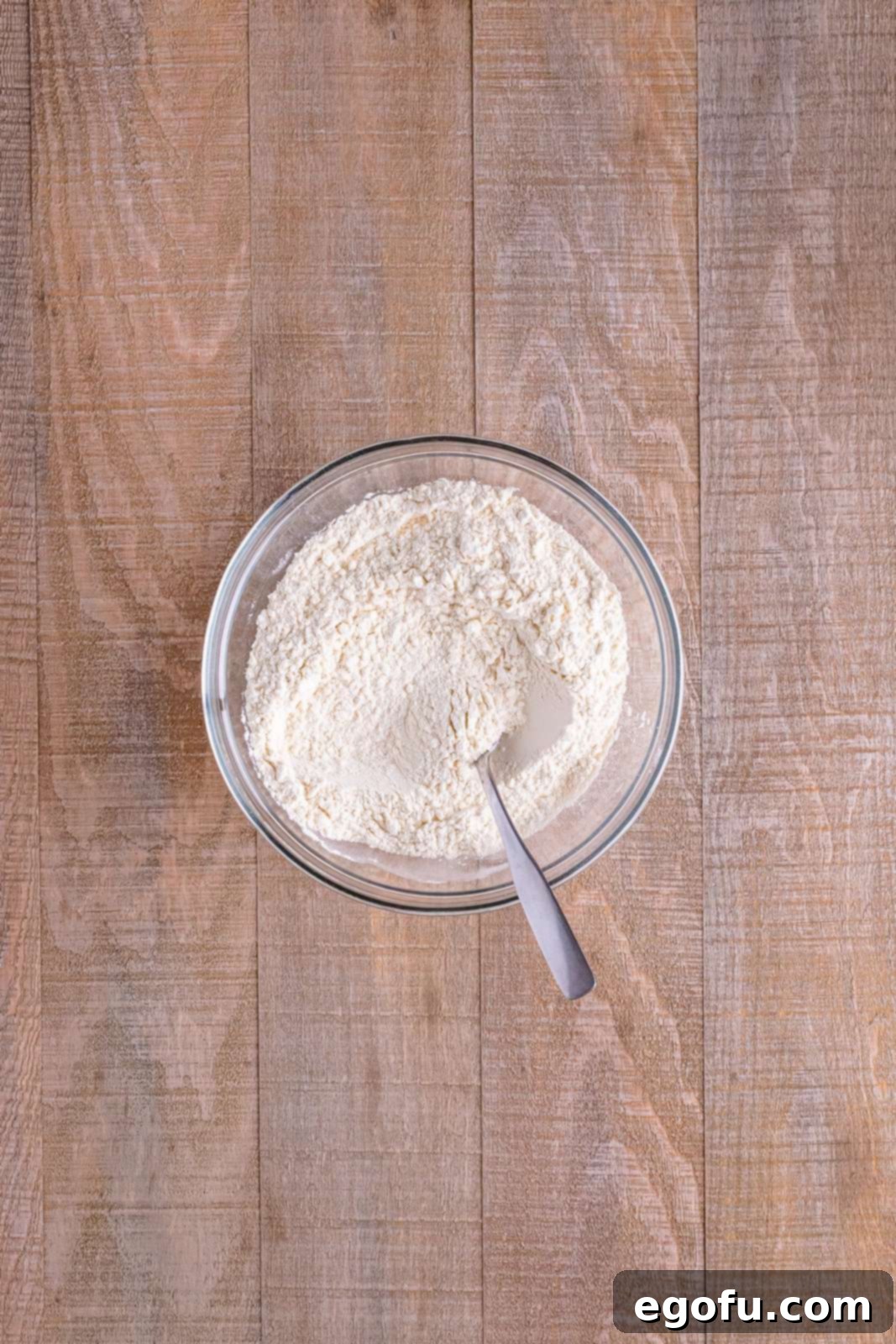 Red Nosed Reindeer Treats 7 flour, baking soda and salt being mixed together by a fork in a white bowl.