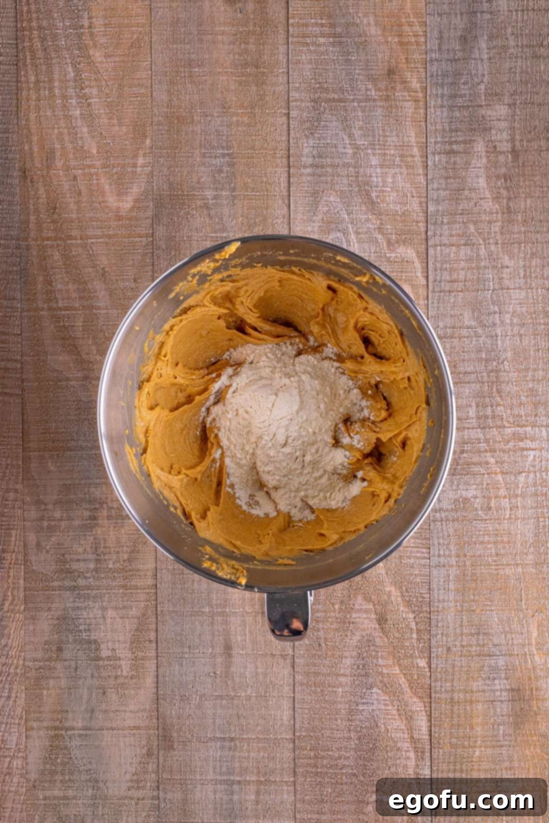 Red Nosed Reindeer Treats 8 flour being added to peanut butter mixture in bowl.