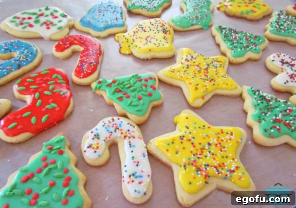 Cut-Out Sugar Cookies with yellow, blue, white and green icing with sprinkles on a sheet of wax paper