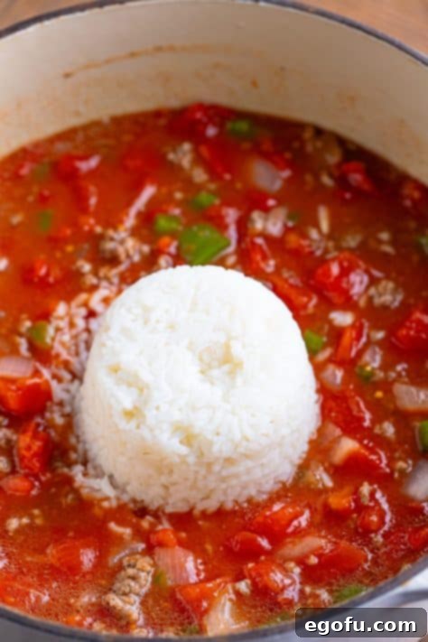 Cooked rice being added to the soup mixture in the pot.