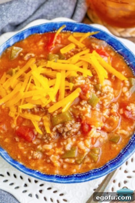 A bowl of Stuffed Pepper Soup topped with shredded cheese.