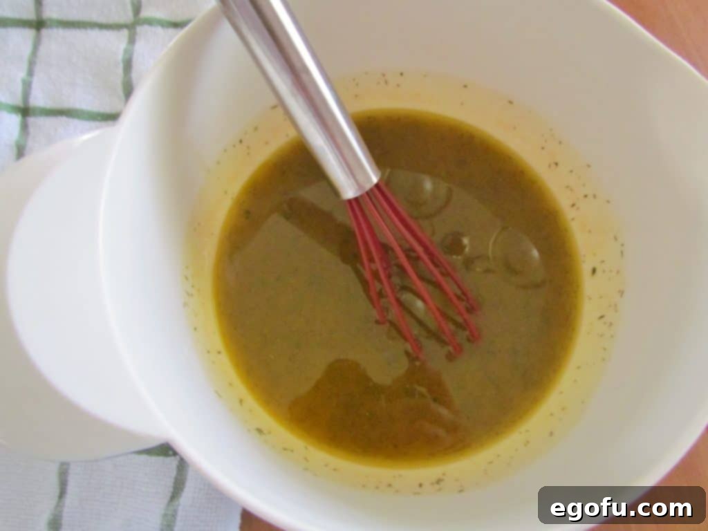 A bowl containing butter-flavored popcorn oil, ranch seasoning, dried dill weed, and garlic powder, mixed together.