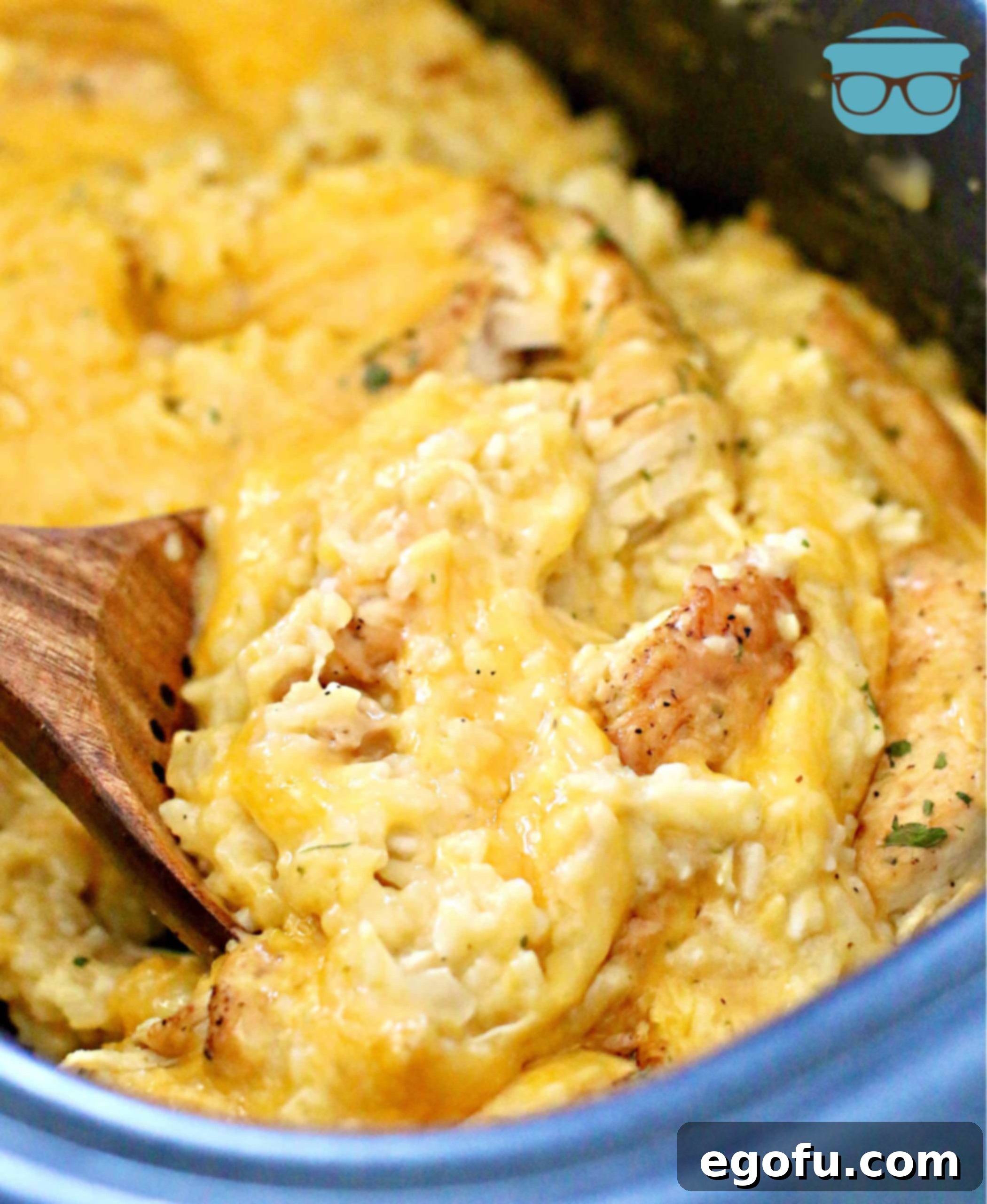 Spoonful of creamy Crock Pot Chicken and Rice in a slow cooker, highlighting its rich texture.