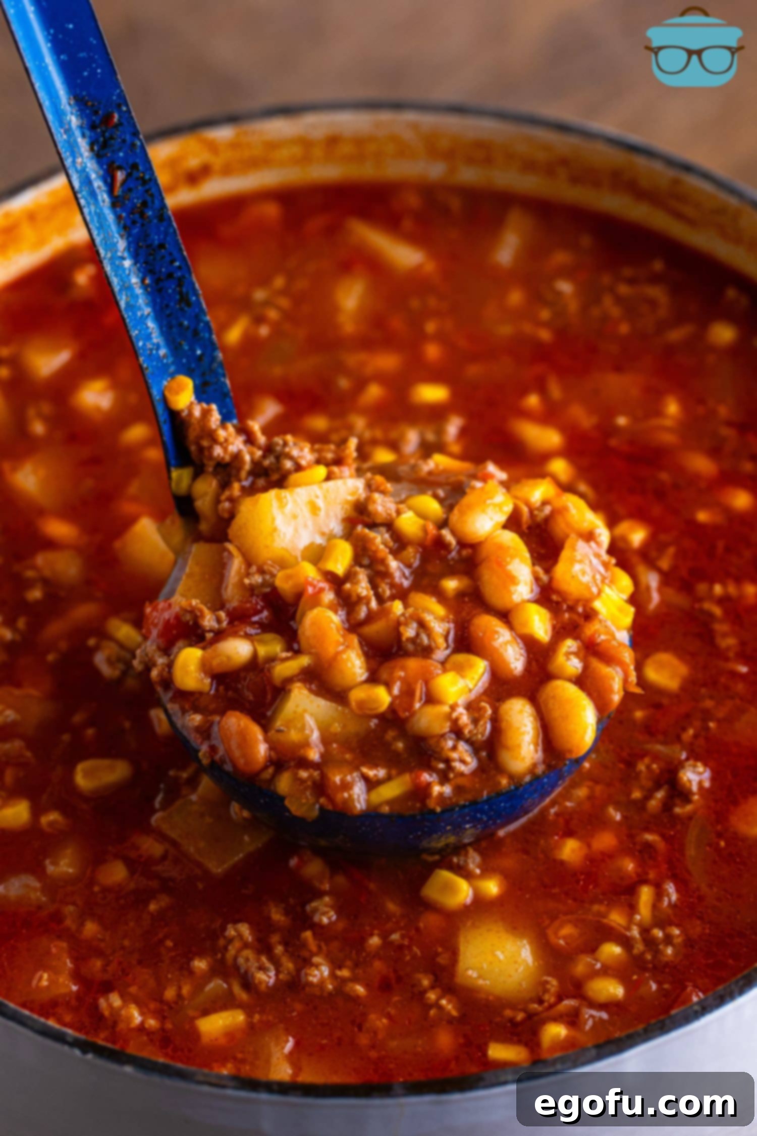 A ladle holding some Brunswick Soup over the rest of the pot.