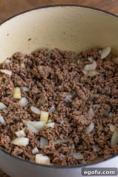 Ground beef and onion in a pot.