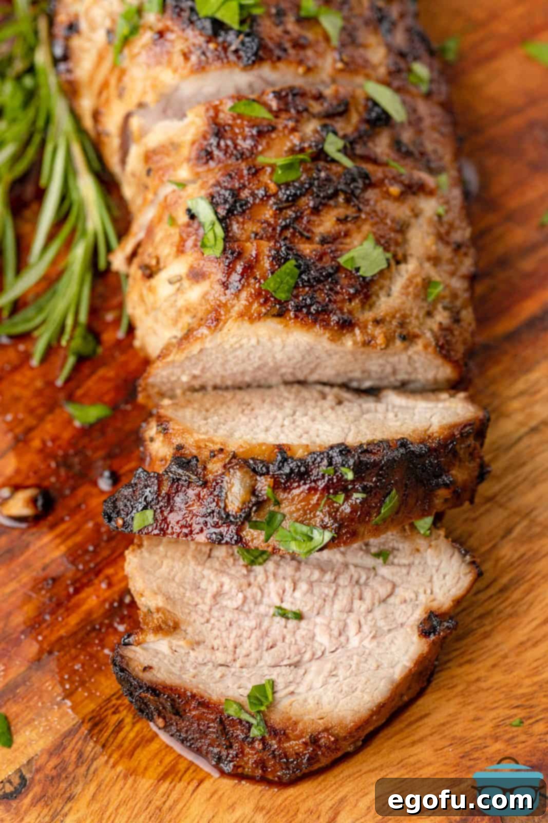 Beautifully sliced Air Fryer Pork Tenderloin laid out on a cutting board, showcasing its tender texture.