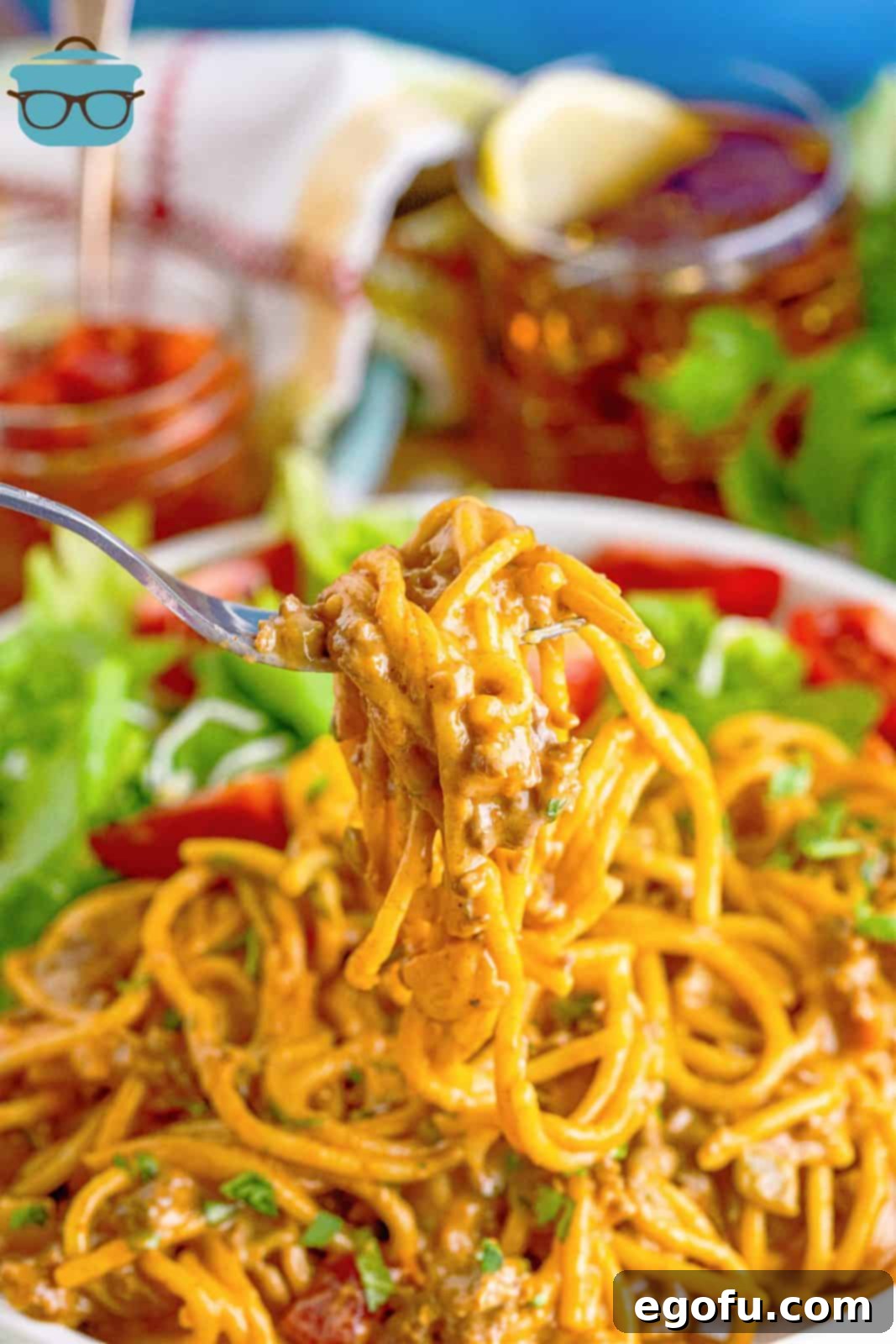 A fork holding up a perfect swirl of creamy Taco Spaghetti from a plate, highlighting the rich sauce and tender noodles.