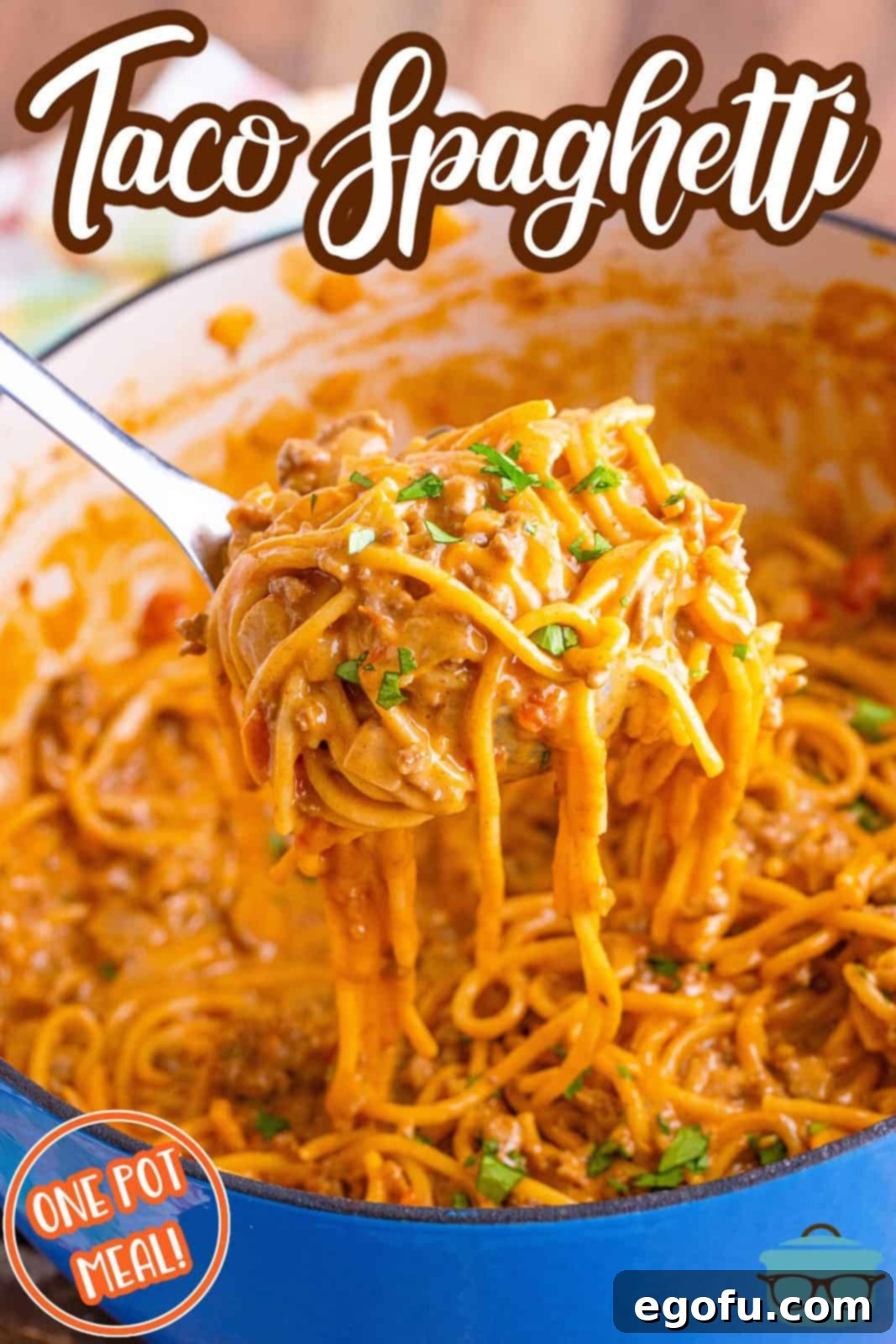 A pasta scoop lifting a generous serving of creamy One Pot Taco Spaghetti from a large cooking pot, showcasing its rich texture.