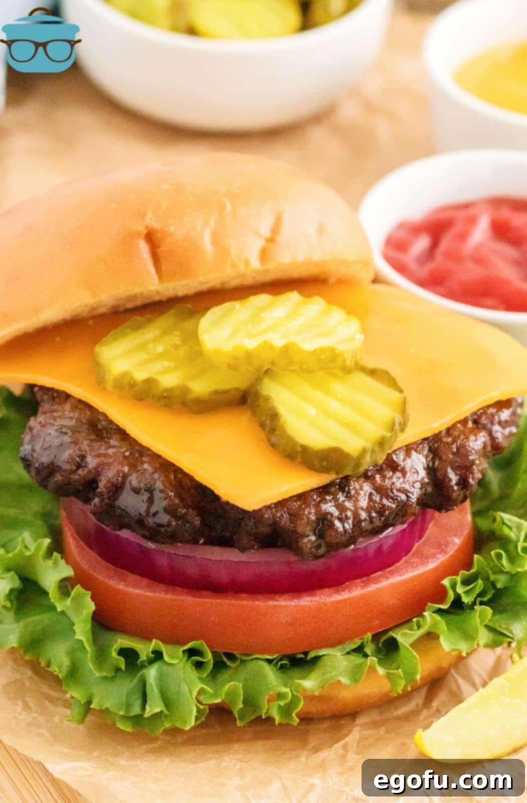 A perfectly cooked Air Fryer Hamburger, presented on a toasted bun with fresh lettuce, ripe tomato, melted cheddar cheese, and crisp pickles.