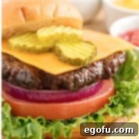 Square image close up of Air Fryer Hamburgers with toppings and bun off to the side.