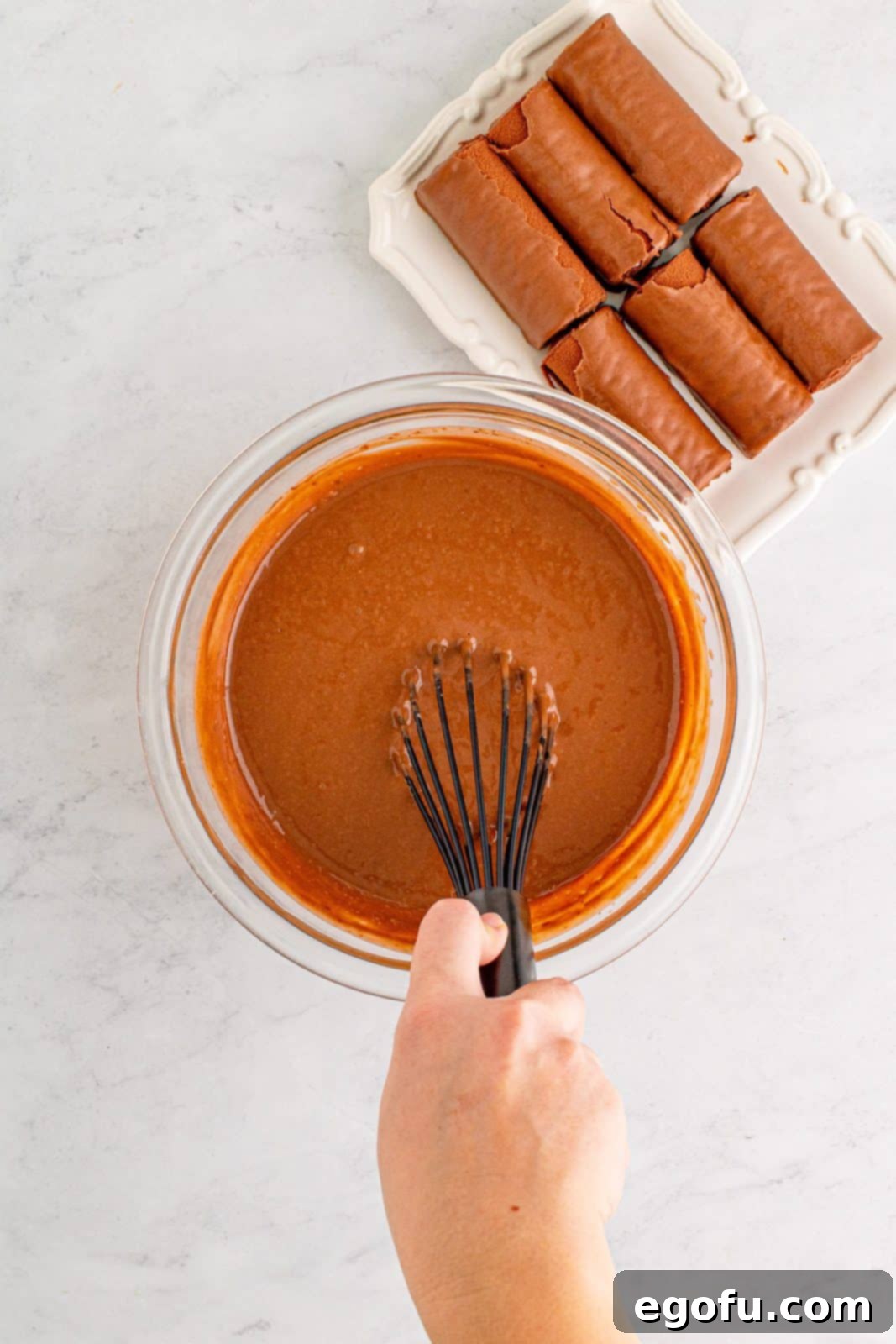 Easy No-Bake Swiss Roll 5 Hand mixing chocolate pudding in bowl.