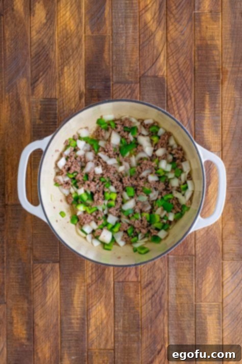 Ground beef, green pepper and onion cooked in a Dutch oven pot.
