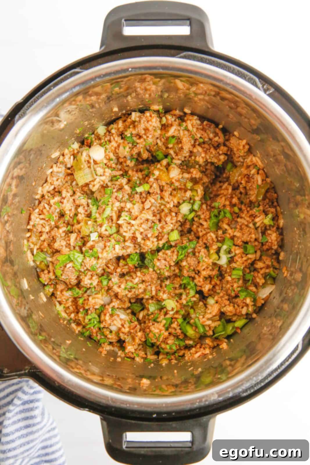The perfectly cooked and fluffy Instant Pot Dirty Rice steaming gently after the lid has been removed, showcasing the rich, 'dirty' color and tender rice grains.