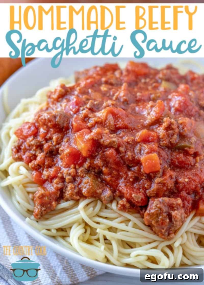 homemade beef spaghetti sauce on a plate of cooked spaghetti noodles.