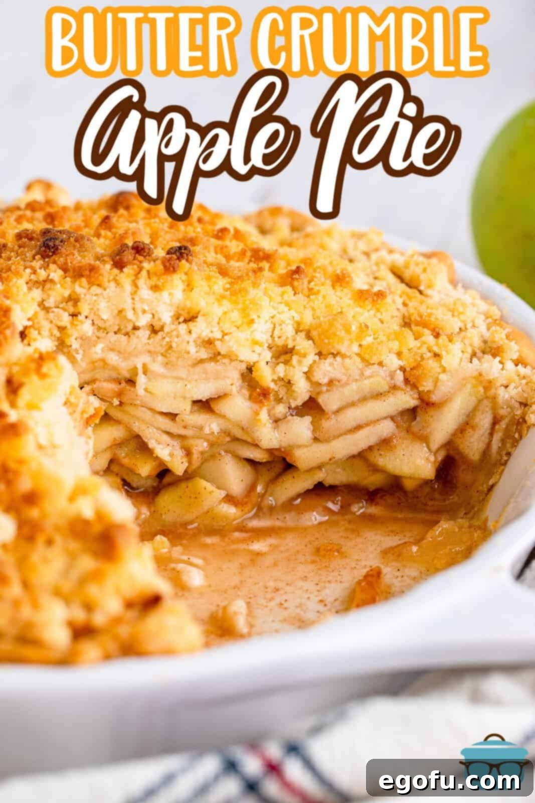A freshly baked butter crumble apple pie cooling in a pie pan, with one piece already removed to reveal the succulent apple filling underneath the golden crumble.