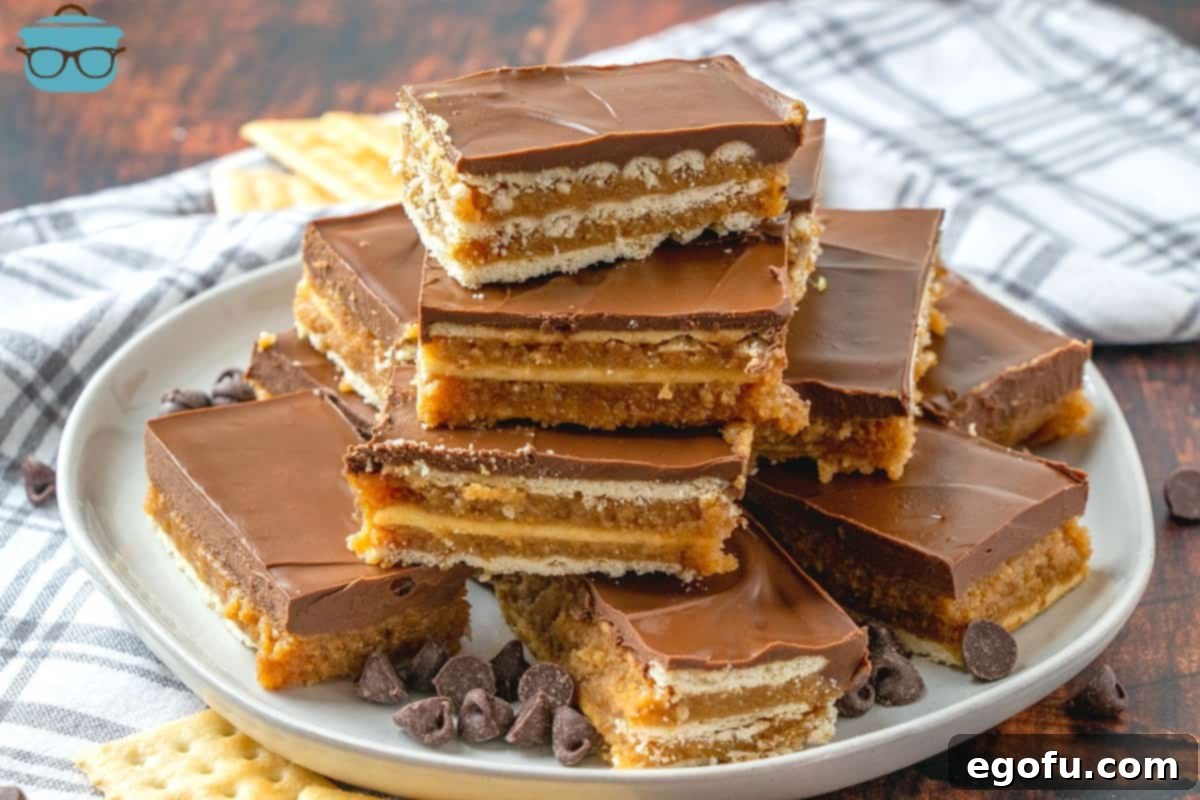 Homemade Kit Kat Bars, sliced and layered on top of a plate with crackers and chocolate chips scattered around.