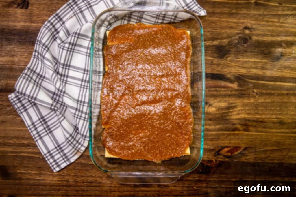 graham cracker butter mixture spread on top of layer of club crackers in a glass baking dish