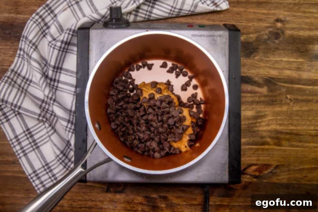 peanut butter and semi-sweet chocolate chips mixed together in a small sauce pot on medium heat