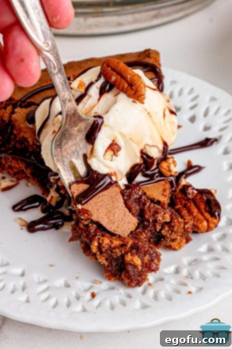 Rich Southern Chocolate Dream 19 A fork taking a bite of a freshly baked Southern Fudge Pie, topped with melting vanilla ice cream and chocolate sauce.