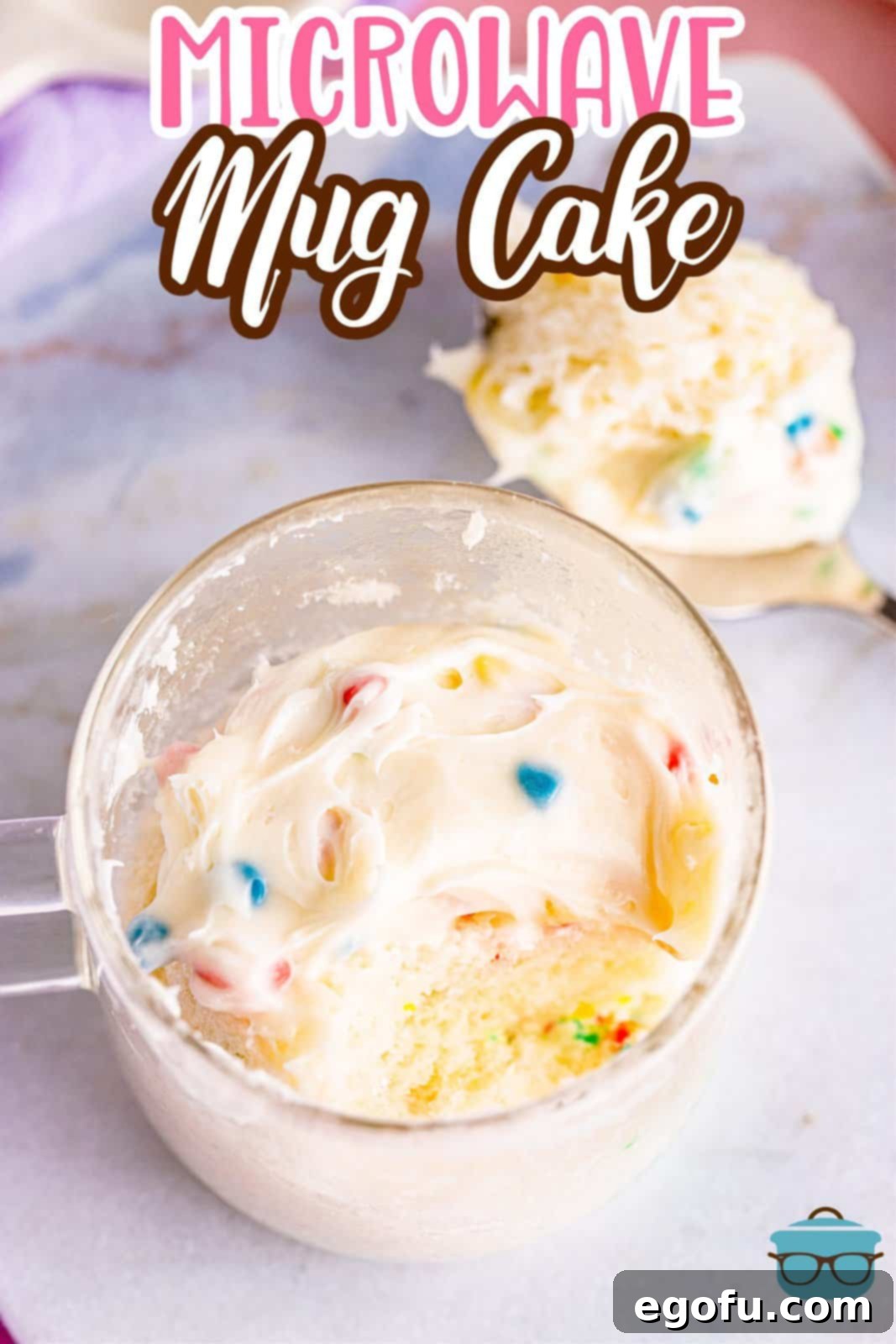 A perfectly microwaved mug cake shown in a clear mug with a small portion removed.
