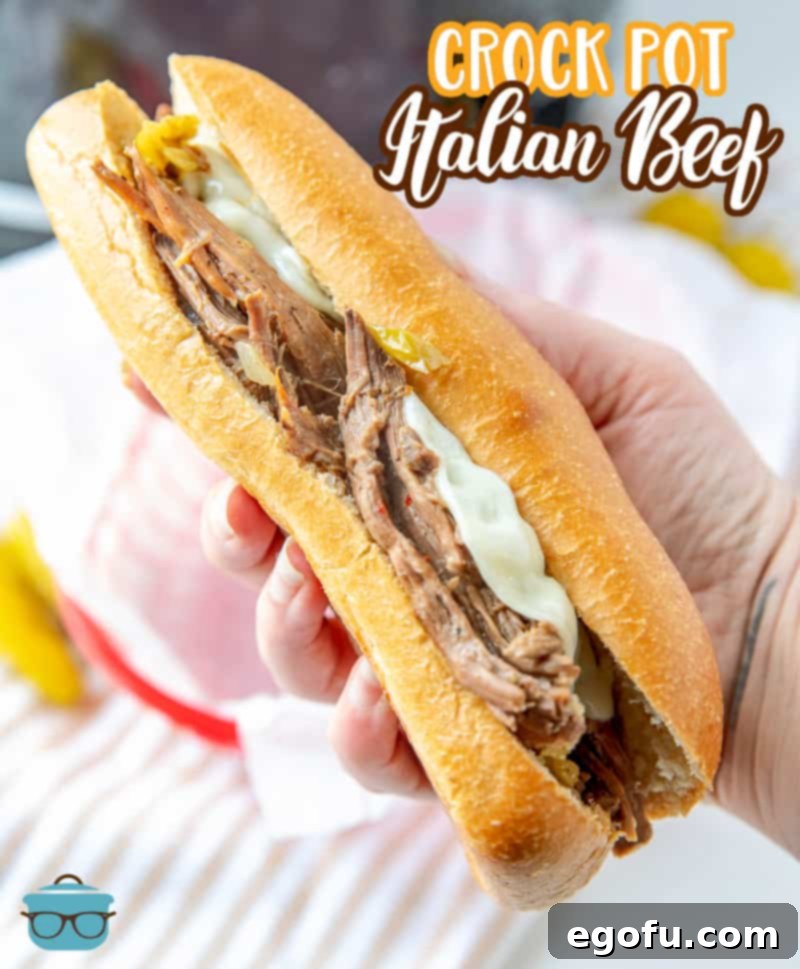 A hand holding up a delicious Italian Beef sandwich, showcasing its rich contents.
