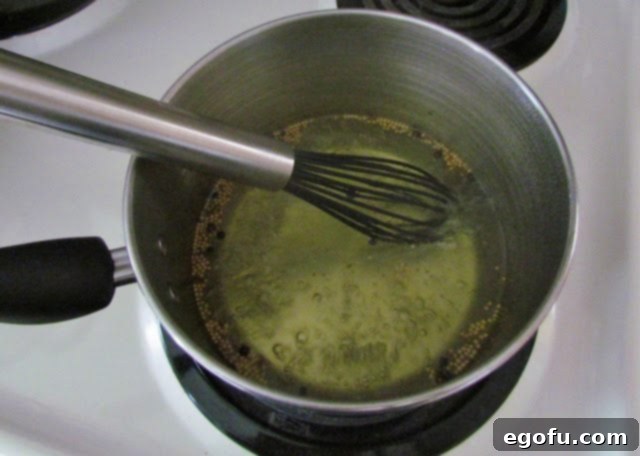 Sweet & Tangy Golden Slices 15 The bread and butter seasoning mix, white vinegar, and granulated sugar mixture gently simmering in a saucepan on the stovetop, reaching a boil.