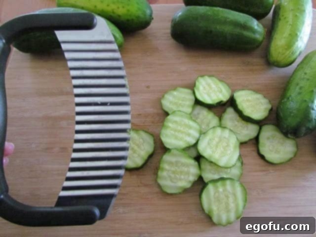 Sweet & Tangy Golden Slices 9 Uniform quarter-inch cucumber slices, exhibiting decorative ridges from a crinkle cutter, neatly piled.