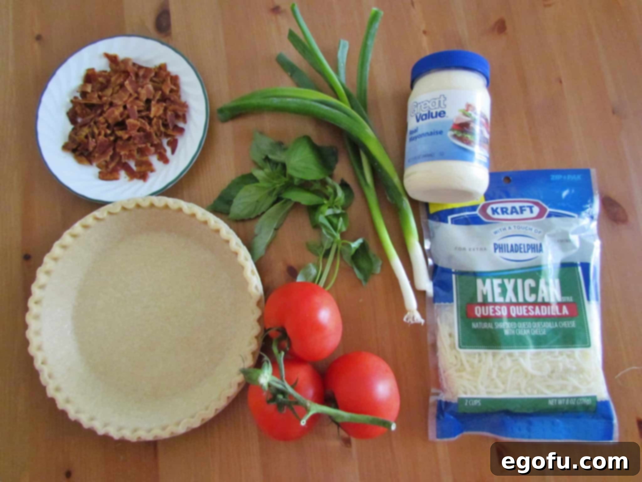 Tomato Pie ingredients: tomatoes, 9-inch frozen pie crust, green onions, basil, chopped bacon, freshly ground black pepper, mayonnaise, shredded mozzarella cheese.