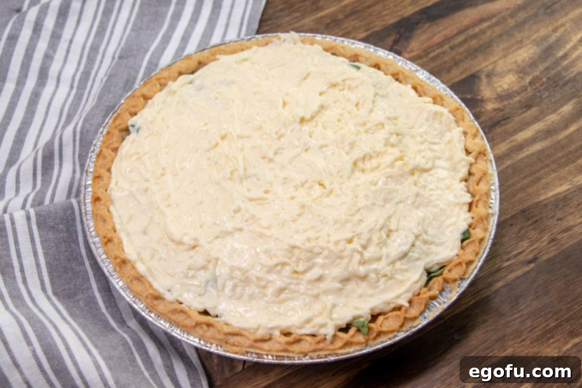 mayonnaise cheese mixture spread out evenly on top of tomato pie.