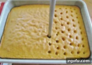 poking holes into baked yellow cake