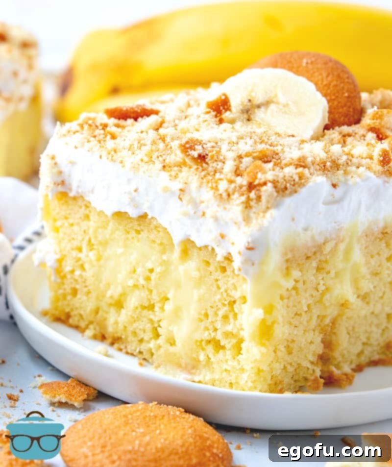 A delectable slice of the Best Banana Poke Cake served on a white plate, highlighting its layers and inviting texture.