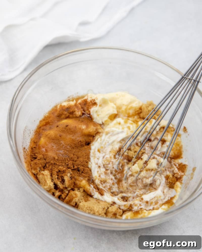 Greek yogurt, mayonnaise, brown sugar and cinnamon whisked together in a bowl.
