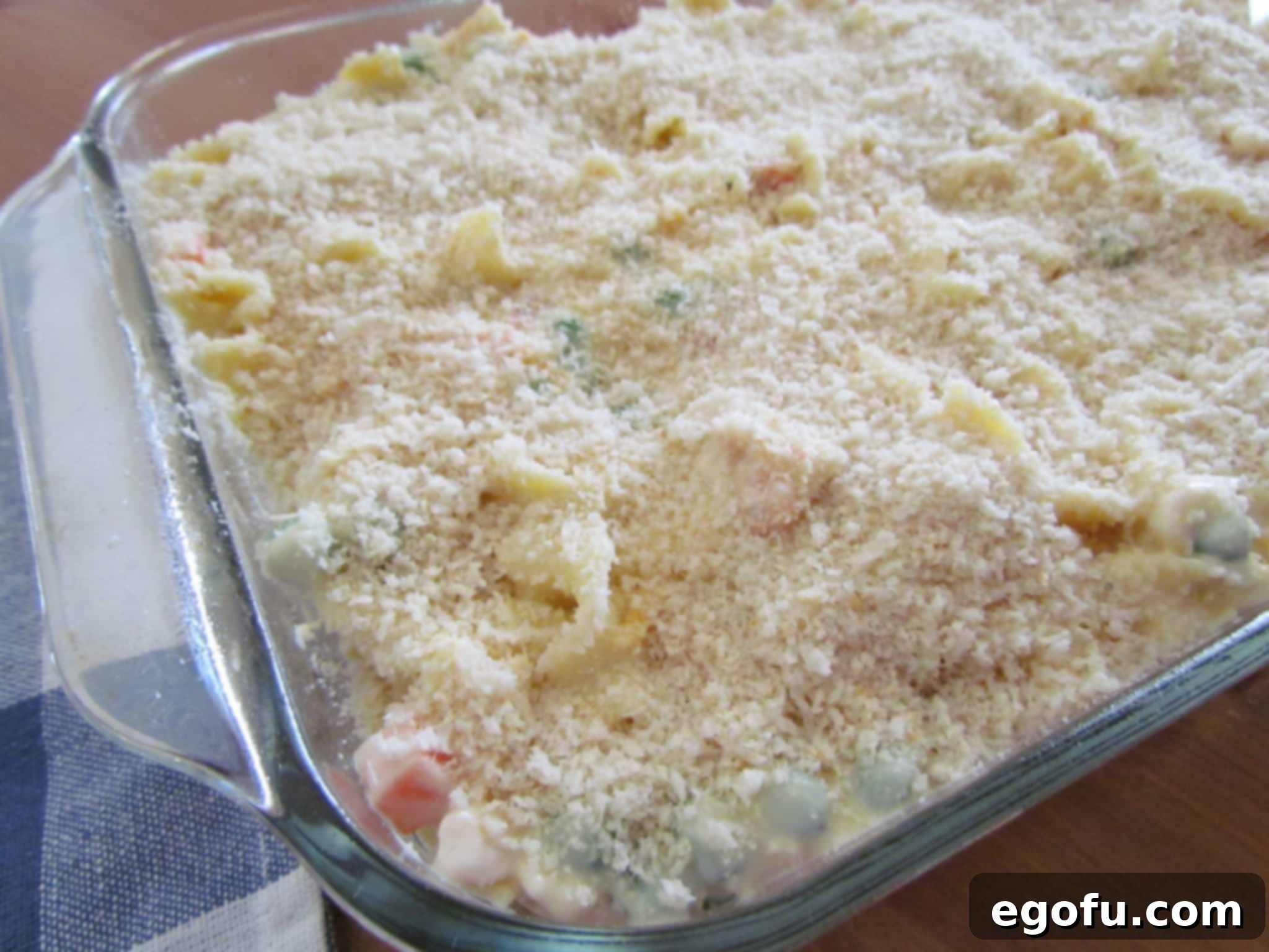 Panko bread crumbs sprinkled on top of the chicken noodle casserole mixture in a 9x13-inch baking dish.