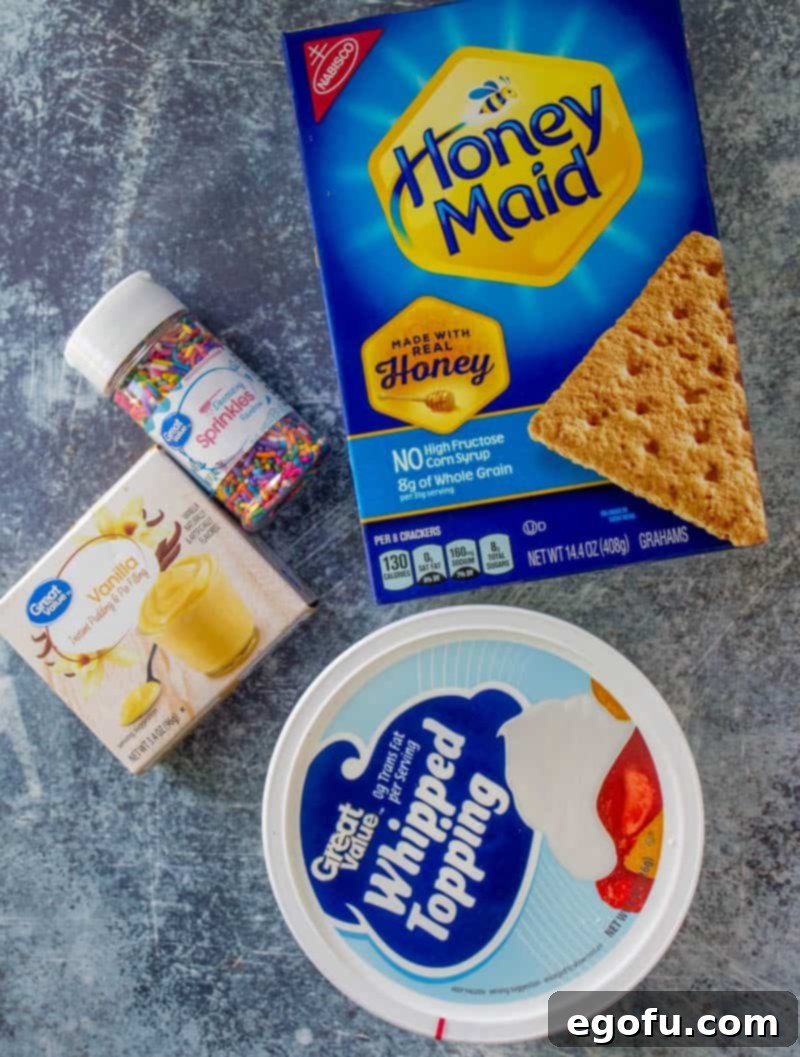 Ingredients laid out: whipped topping, instant vanilla pudding mix, colorful sprinkles, and graham cracker squares. All you need for an easy no-bake dessert.