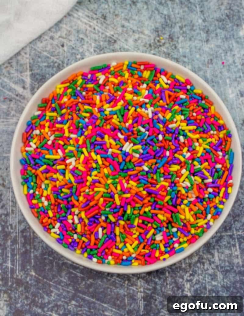 Colorful sprinkles in a bowl, ready for dipping the graham cracker goodies, adding a fun, festive touch.