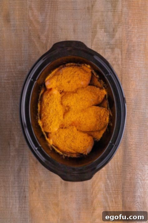 Effortless Slow Cooker Taco Chicken 11 Taco seasoning covered chicken breasts in a crock pot.