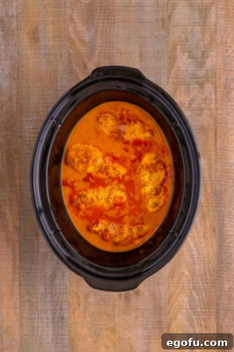 Effortless Slow Cooker Taco Chicken 13 A slow cooker full of cooked Shredded Chicken for tacos.