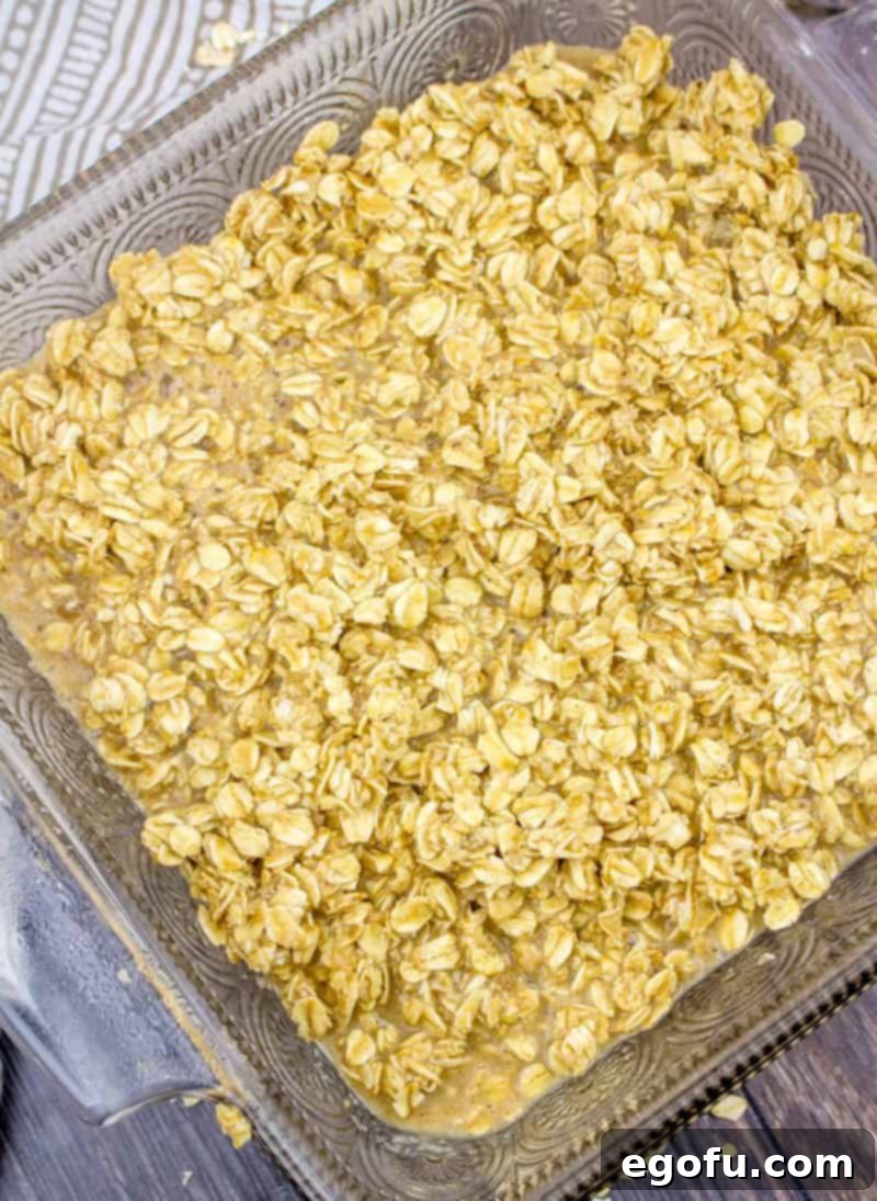 The finished oatmeal batter poured smoothly and evenly into an 8-inch square baking dish, ready for the oven to transform it into a delicious breakfast.